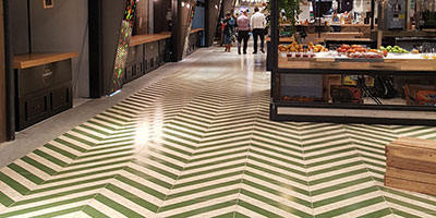 OSB like porcelain tile with green stripes on the OSHI Market floor